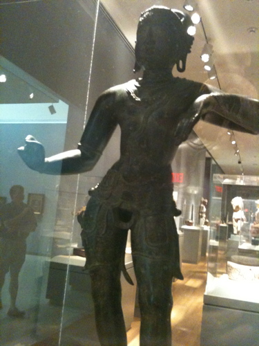 A bronze statue of the Hindu god Shiva, standing. Where his phallus should be is a gaping hole.